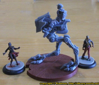 Size comparison of Star Wars: Legion Core Set miniatures from Fantasy Flight Games with 1:50 (35mm) scale miniature figures. From left to right: Female Walker Zombie #2 for Zombicide from CoolMiniOrNot, AT-RT for Star Wars: Legion,  Male Walker Zombie #2 for Zombicide from CoolMiniOrNot.